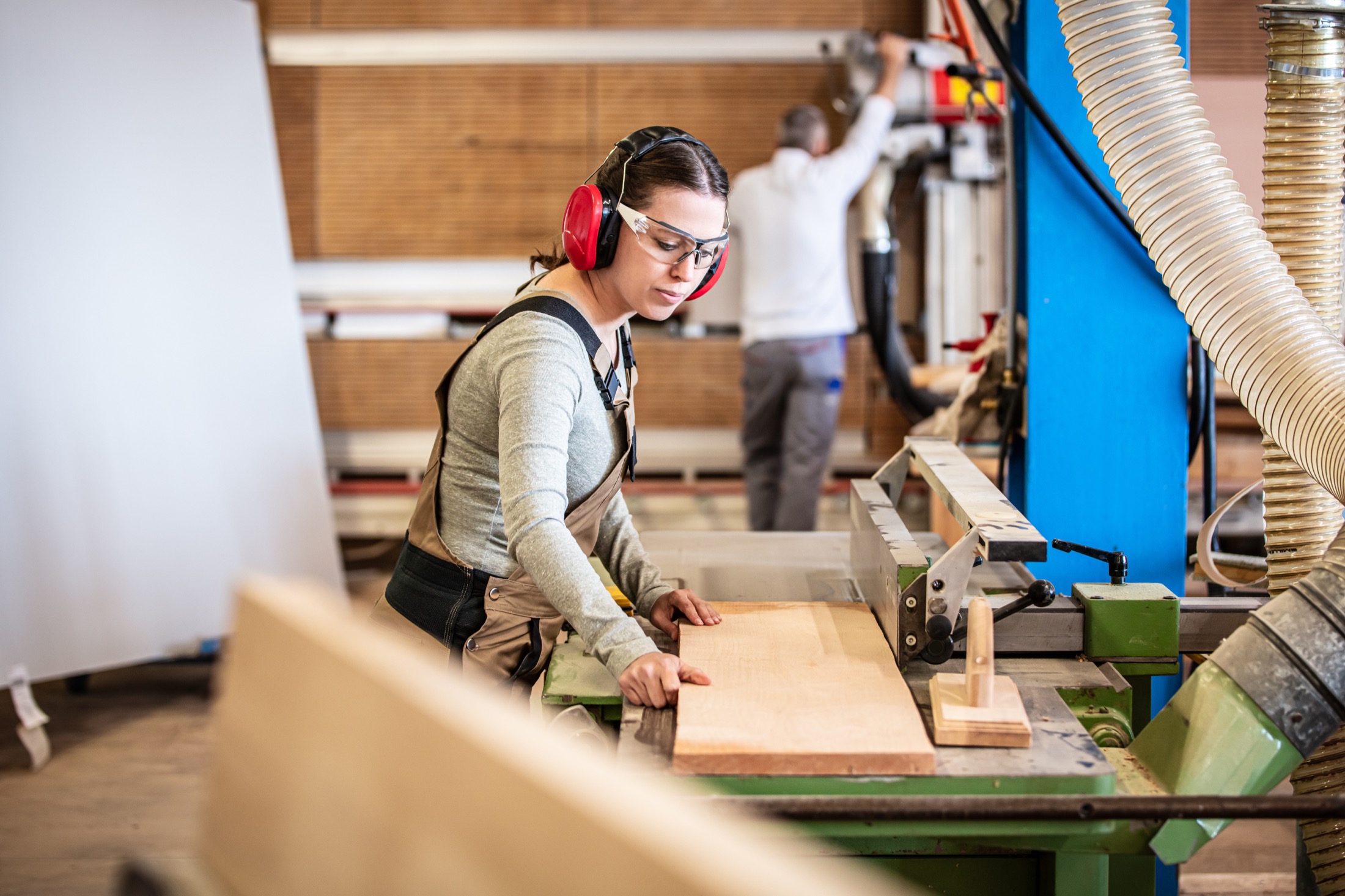 Tradesperson working safely with timber machinery in a workshop